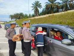 Kasat Lantas Polres Siak Bagikan Air Mineral dan Roti untuk Pemudik di Tol Permai